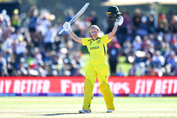 CHRISTCHURCH, NEW ZEALAND - APRIL 03: Alyssa Healy of Australia celebrates her century during the 2022 ICC Women's Cricket World Cup Final match between Australia and England at Hagley Oval on April 03, 2022 in Christchurch, New Zealand. (Photo by Hannah Peters/Getty Images)